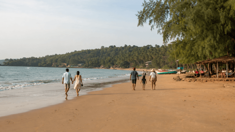 Keri Beach Goa shoreline with visitors walking on the sand, fishing boats, beach shacks and a calm North Goa coastal view
