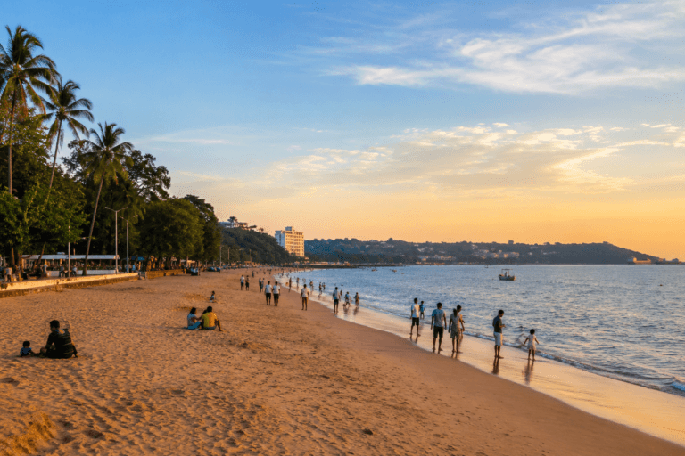 Miramar Beach Goa near Panjim with families walking on the sand, palm trees, calm sea, evening light and Mandovi side coastal view