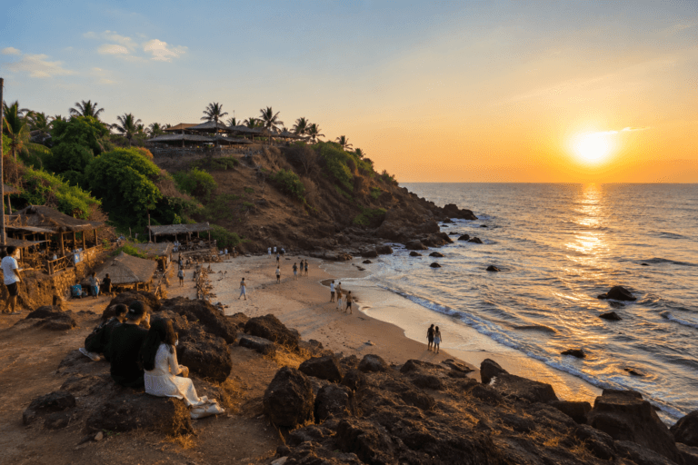 Ozran Beach Goa near Little Vagator with rocky shoreline, sunset view, beach visitors, cliff side cafes and calm sea
