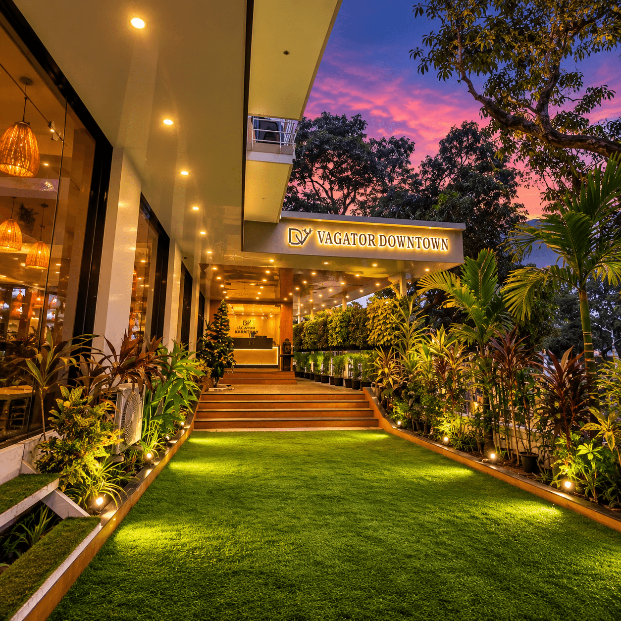 Lit-up entrance steps and garden of Vagator Downtown by WS at night in Vagator Goa