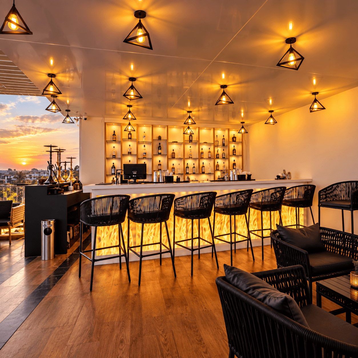 Rooftop bar with bar stools and hanging lights at Vagator Downtown by WS Goa