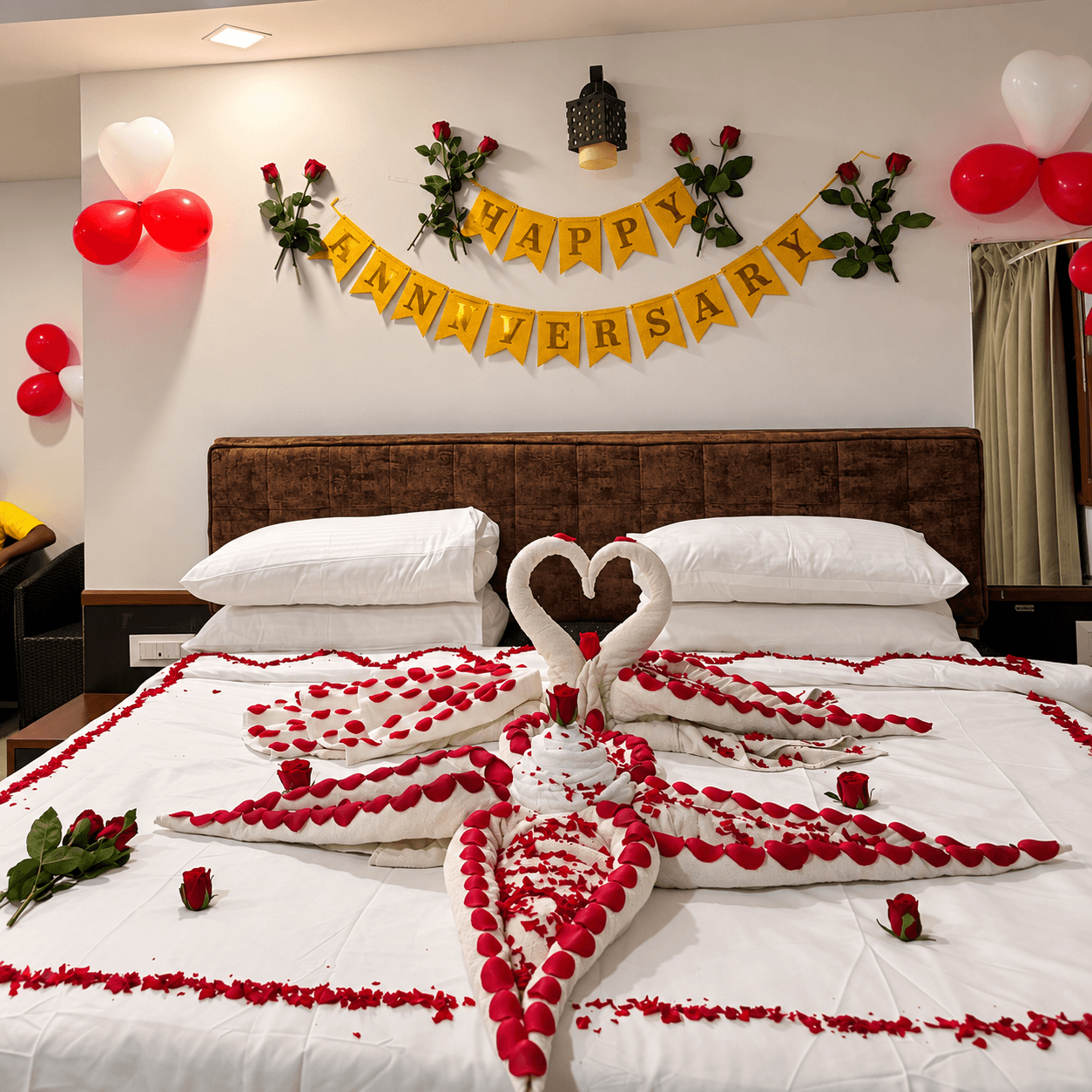 Honeymoon bed with swan towels, rose petals, balloons and flowers at Resorte Village Royale Goa