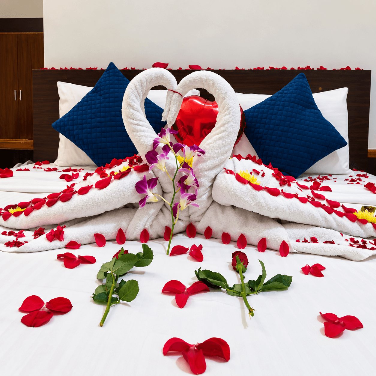 Swan towel art with flowers and rose petals on honeymoon bed at Resorte Village Royale Goa
