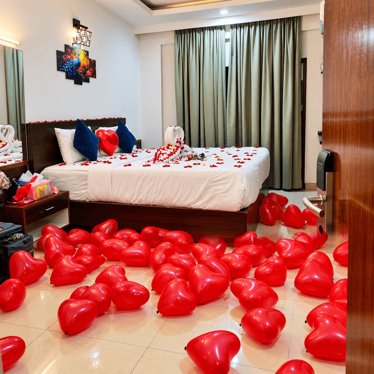 Honeymoon room decorated with red heart balloons and rose petals at Resorte Village Royale Calangute Goa