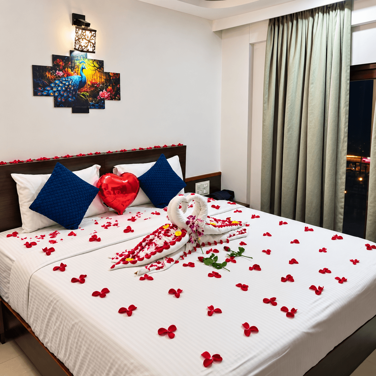 Honeymoon bed decorated with rose petals, heart and towel art at Resorte Village Royale Calangute