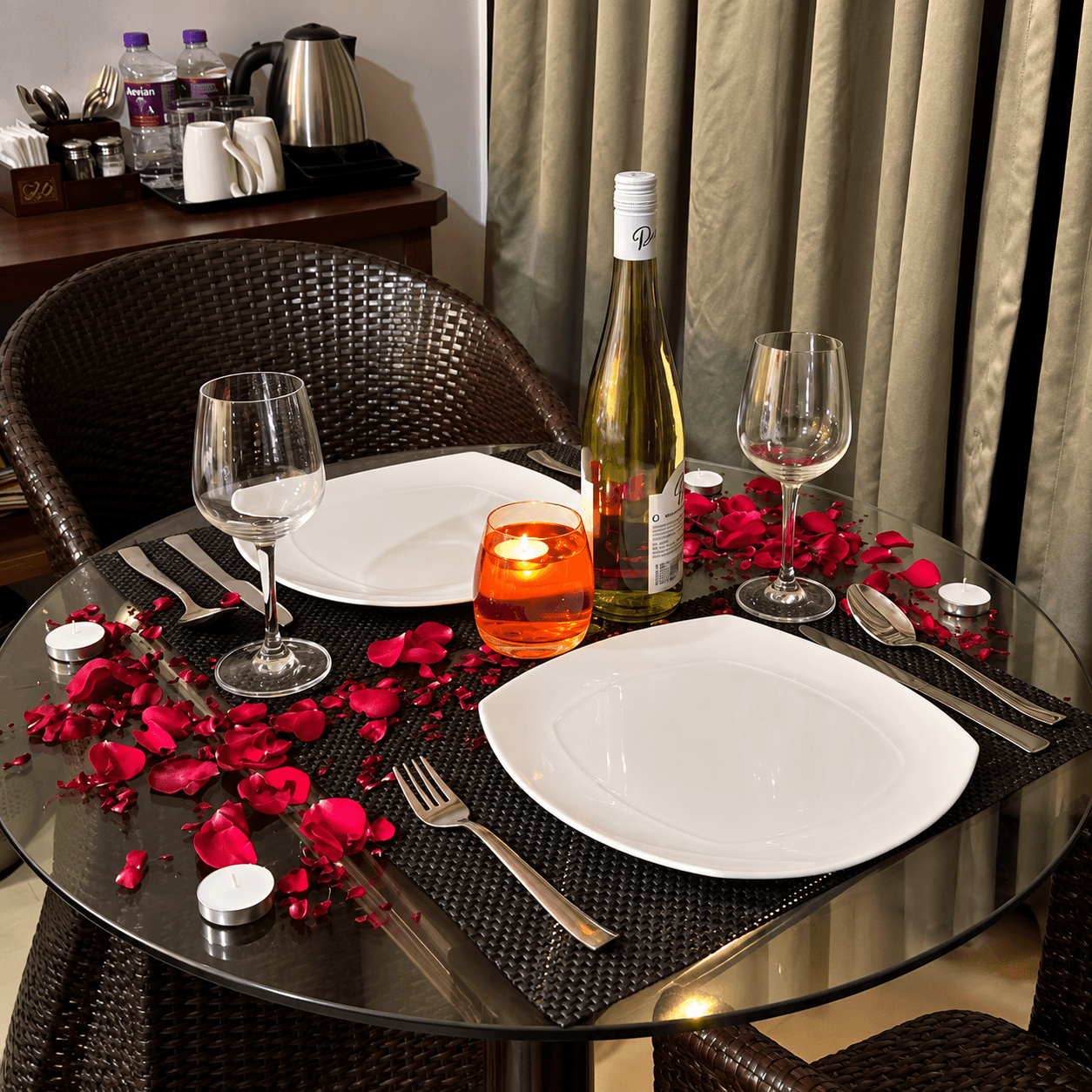 Romantic candle light dinner table with wine and rose petals for Goa honeymoon package at Resorte Village Royale
